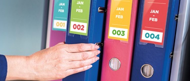 4 folders with different colour labels and a hand picking one off the shelf